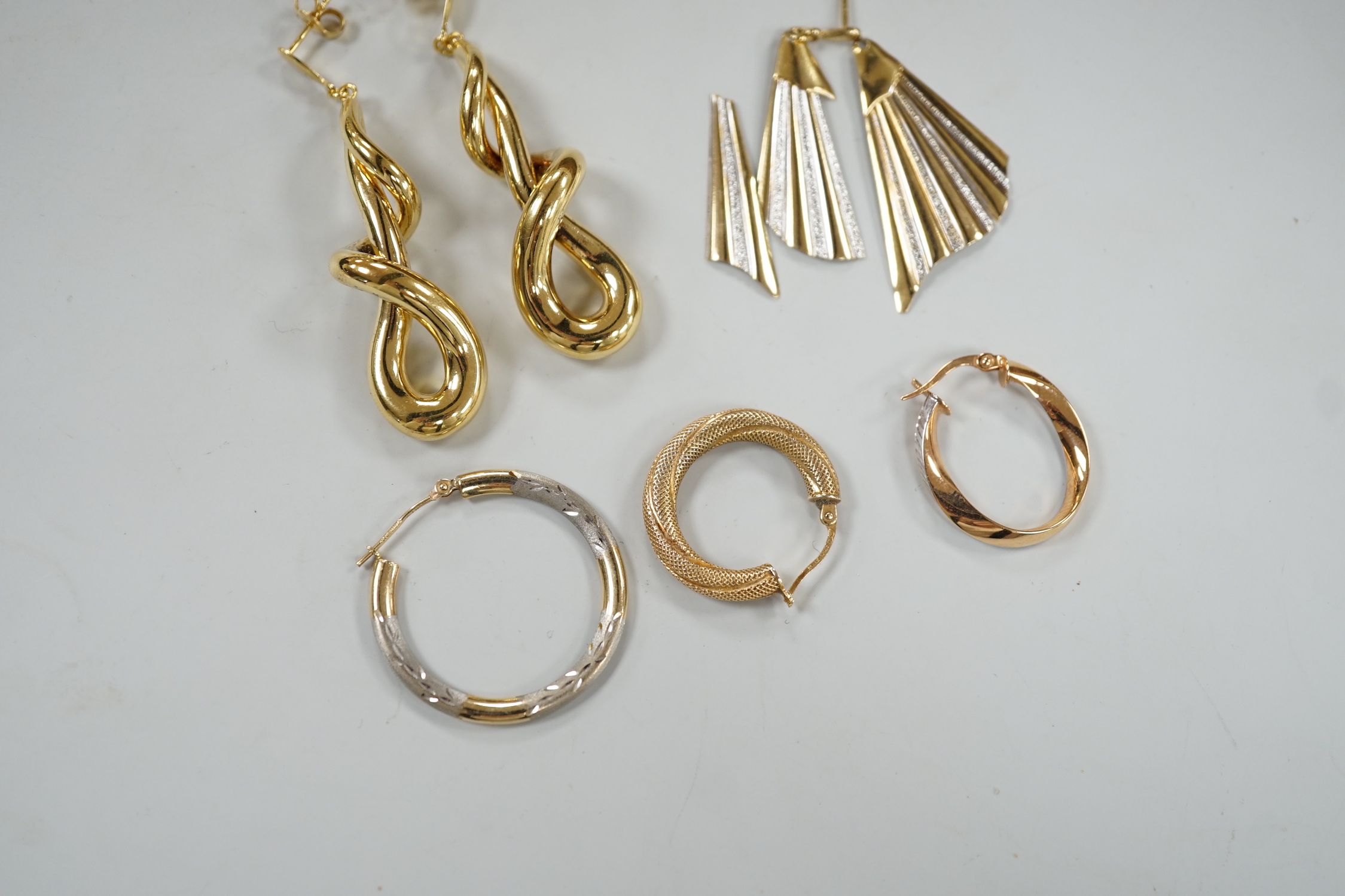 A modern pair of 9ct gold scrolling drop earrings, 47mm, three odd 9ct gold earrings and three 9ct earring fragments, 13.4 grams.